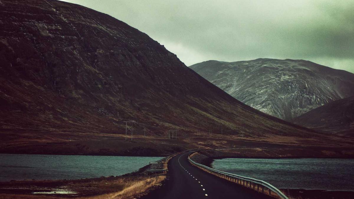 一位工程师与家庭主人在监视器前观察家政机器人工作的画面，背景是正在下雪的窗外